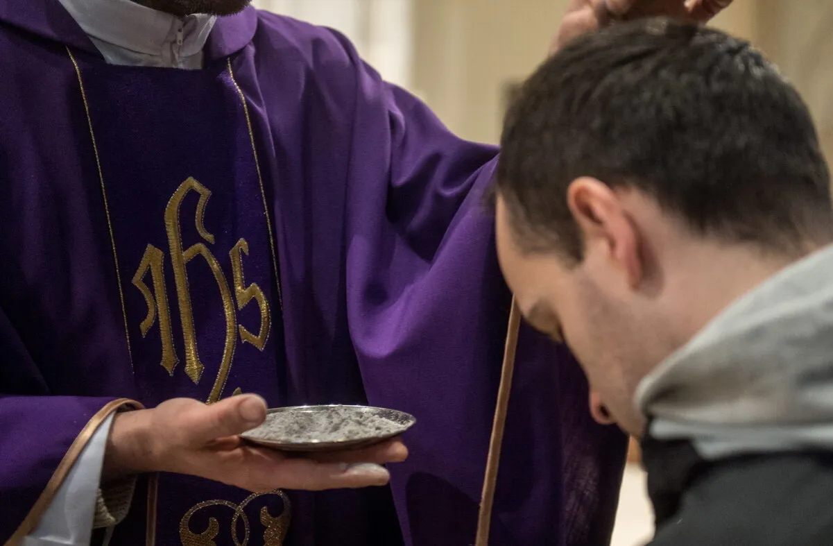 ksiądz sypiący popi&oacute;ł na głowę