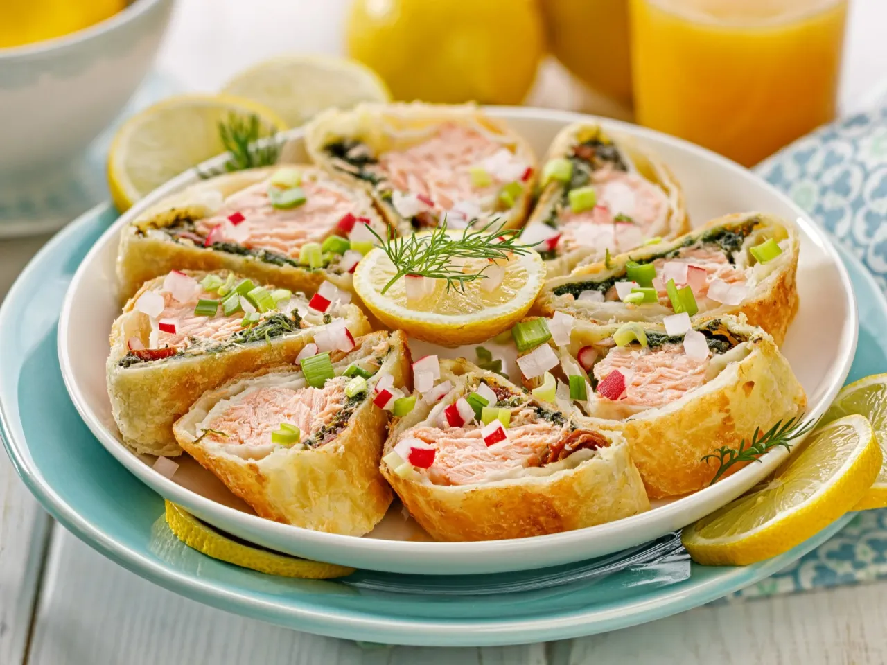 Roladki z łososiem w cieście francuskim, posypane szczypiorkiem i rzodkiewką. Idealne, gdy zastanawiasz się, jak zrobić ciasto na ryby z mąki.