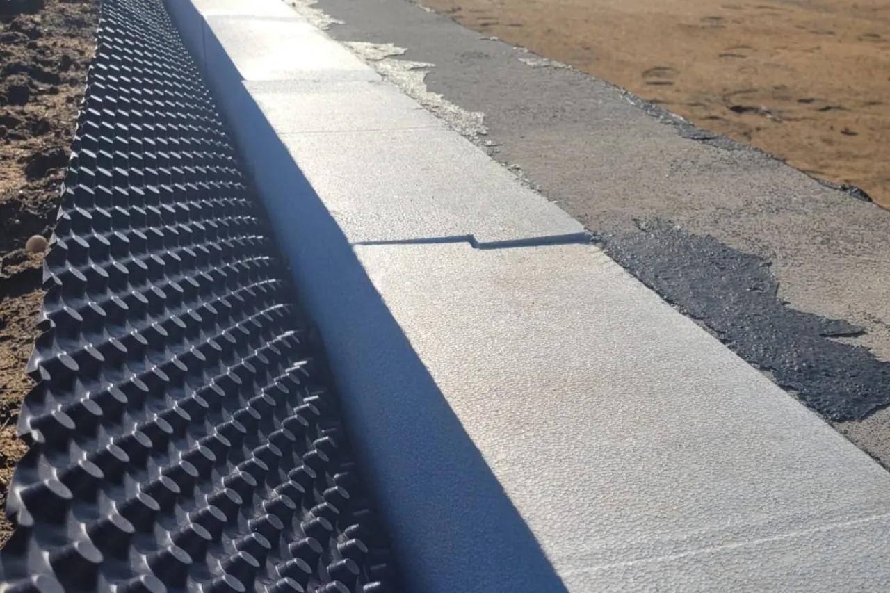 Warstwa drenażowa i izolacja styropianowa to kluczowe elementy, jak ocieplić fundament. Zabezpieczają przed wilgocią i zimnem.