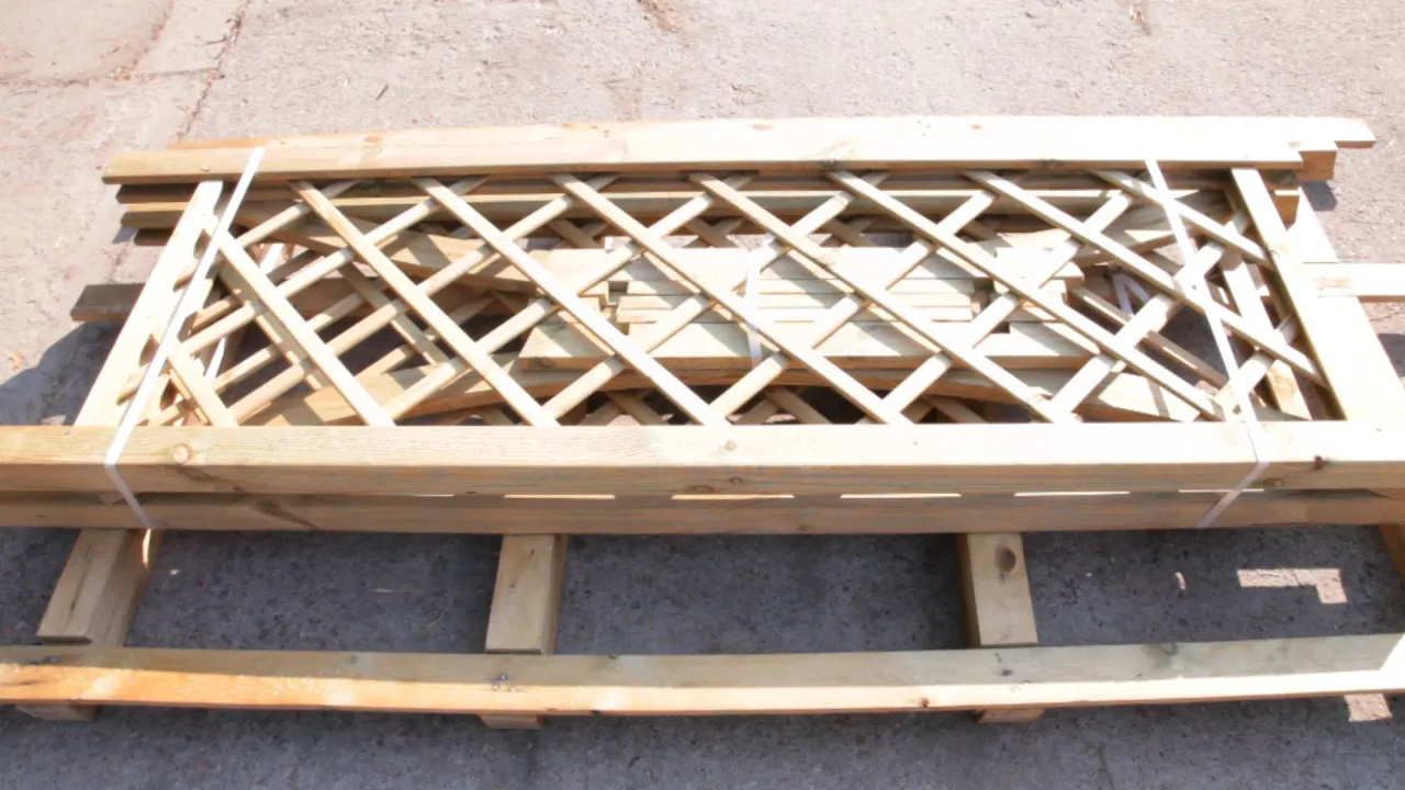 Drewniane elementy do budowy pergoli, kratownica i belki, gotowe do montażu.