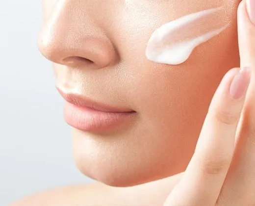 kobieta aplikująca lekki krem na twarz