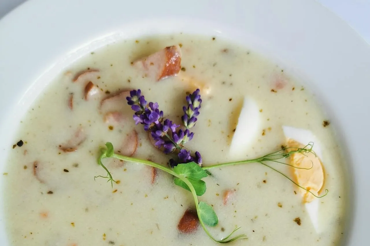 Żur z kiełbasą i jajkiem, ozdobiony gałązką lawendy i kiełkami. Idealne jakie przyprawy do żuru?