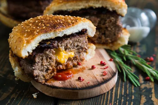 burger z serem w środku przekrojony na p&oacute;ł