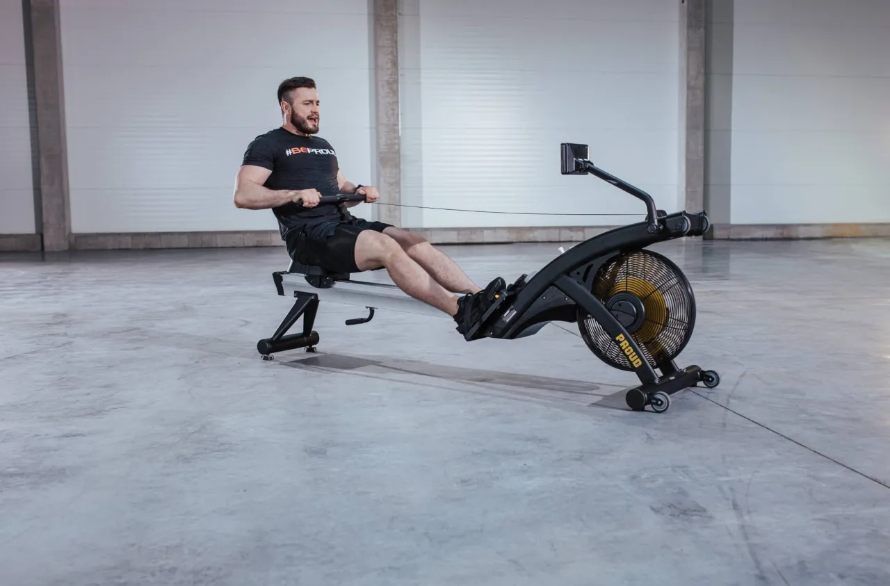 Mężczyzna ćwiczy na wioślarzu. Czy robic cardio na masie? To pytanie zadaje sobie wielu, a taki trening to świetny sposób na poprawę kondycji.