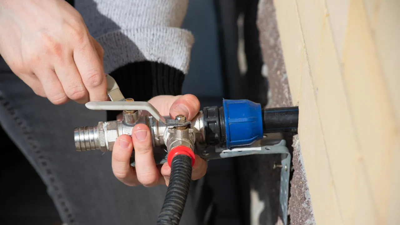 man checking garden hose pressure gauge