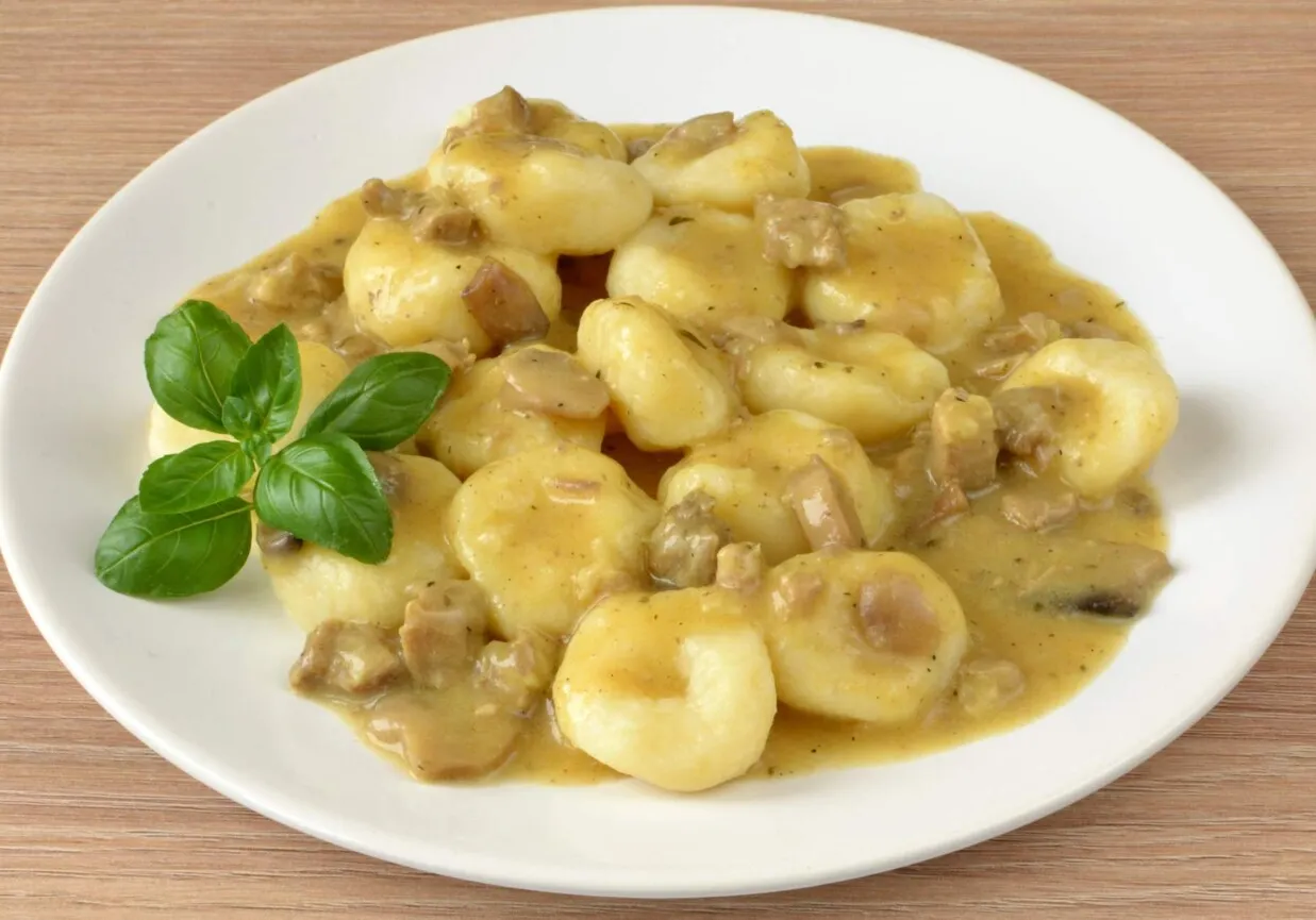 Pyszne kluski śląskie w sosie grzybowym z kawałkami grzybów i mięsa. Idealne danie, które świetnie smakuje i pokazuje, co pasuje do sosu grzybowego.