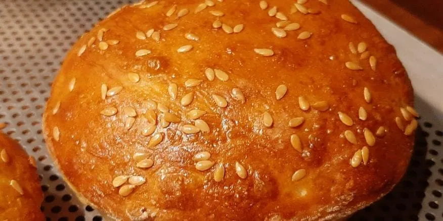 pains à burger maison dorés avec graines de sésame sur une grille