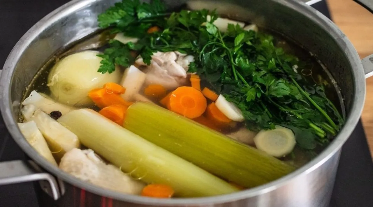 Gotujesz rosół? W garnku bulion z warzywami: marchewka, seler, por, cebula i natka pietruszki. Idealne do mrożenia warzyw na rosół.