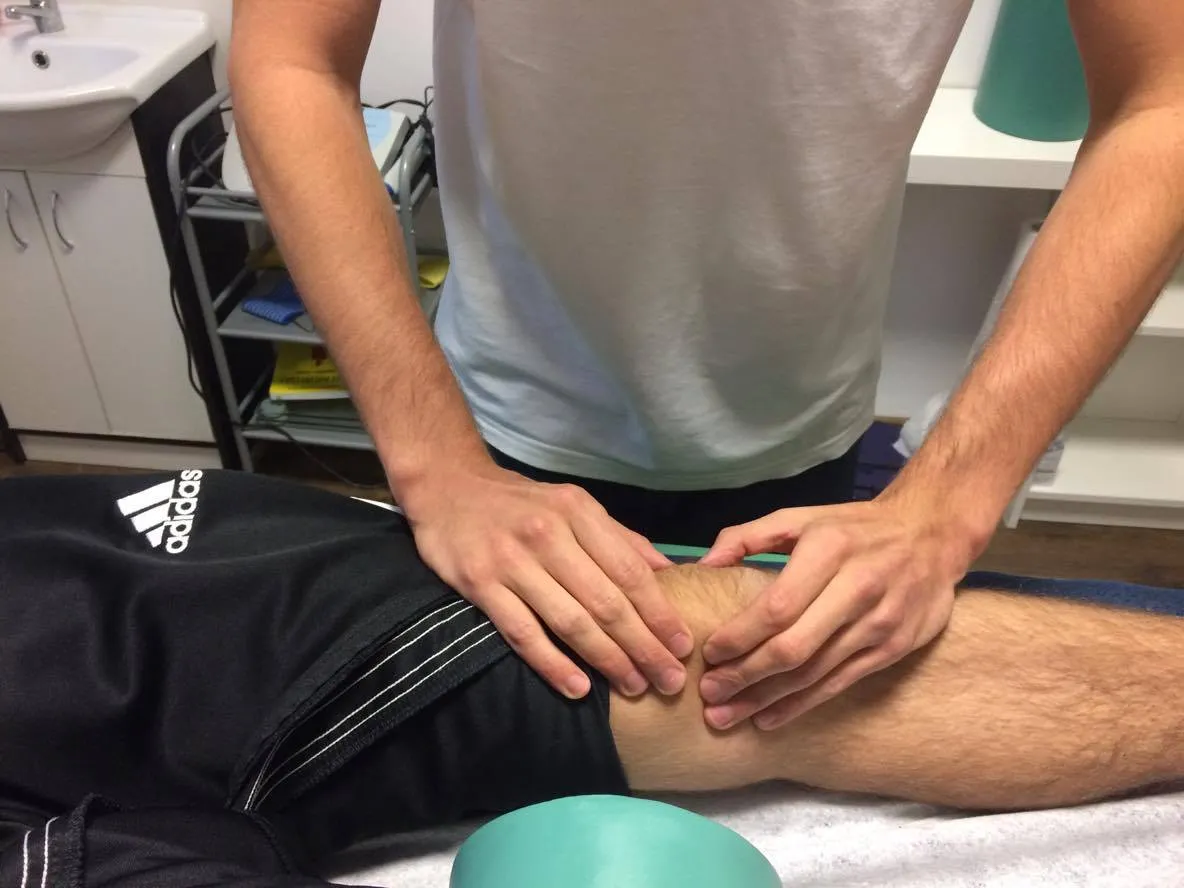 Sportowiec po kontuzji kolana rehabilitowany przez fizjoterapeutę