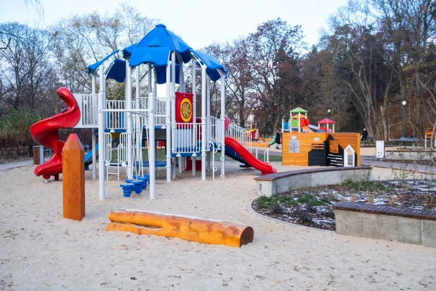 Rodzic sprawdzający bezpieczeństwo urządzeń na placu zabaw