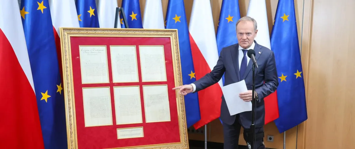 Donald Tusk na tle flag Unii Europejskiej i Polski