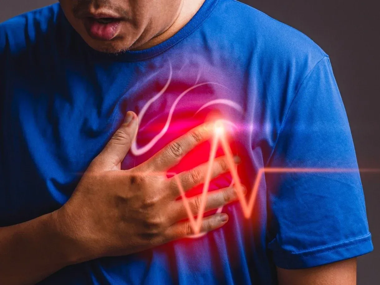 osoba z objawami nerwicy serca, trzymająca się za klatkę piersiową, zaniepokojona