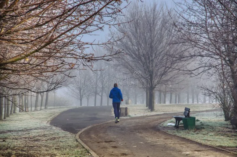 osoba biegająca w parku o poranku
