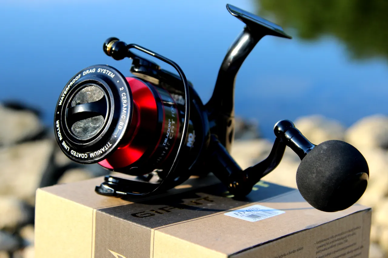 Idealny kołowrotek do spinningu na szczupaka: czarny, z czerwonym elementem, wodoodporny, z systemem 2 ceramicznych łożysk.
