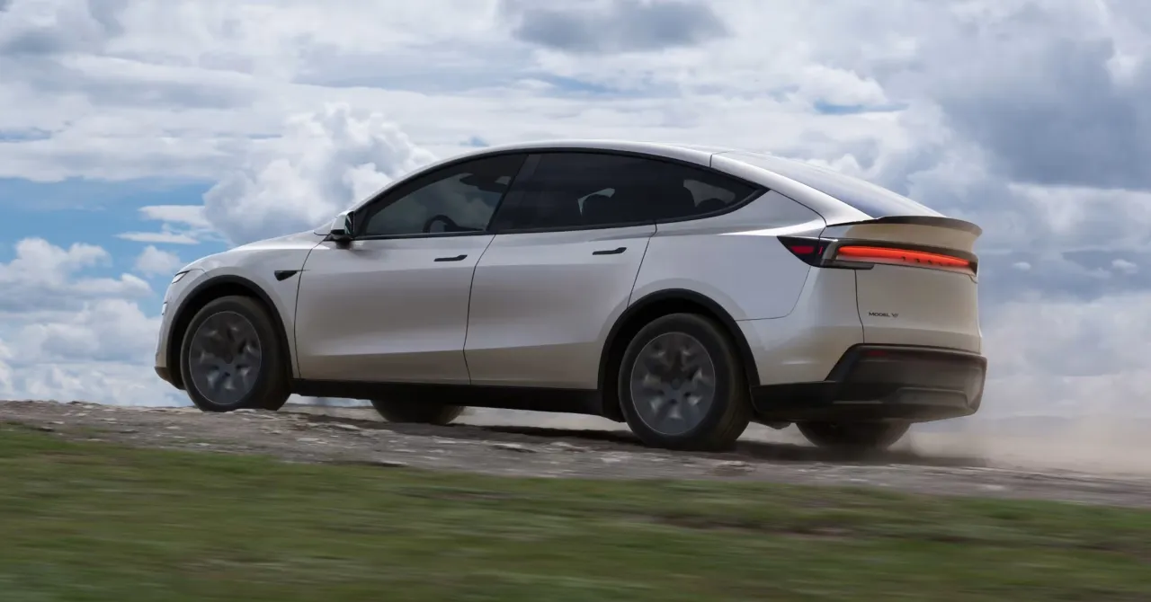 Biały Tesla Model Y jedzie po piaszczystej drodze. Czy Tesla jest tylko elektryczna? Ten SUV pokazuje, że może pokonywać różne tereny.