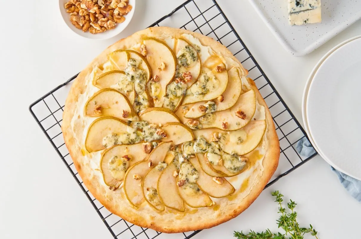 Pyszne ciasto francuskie z gruszkami i gorgonzolą, posypane orzechami. Idealna przekąska na każdą okazję.