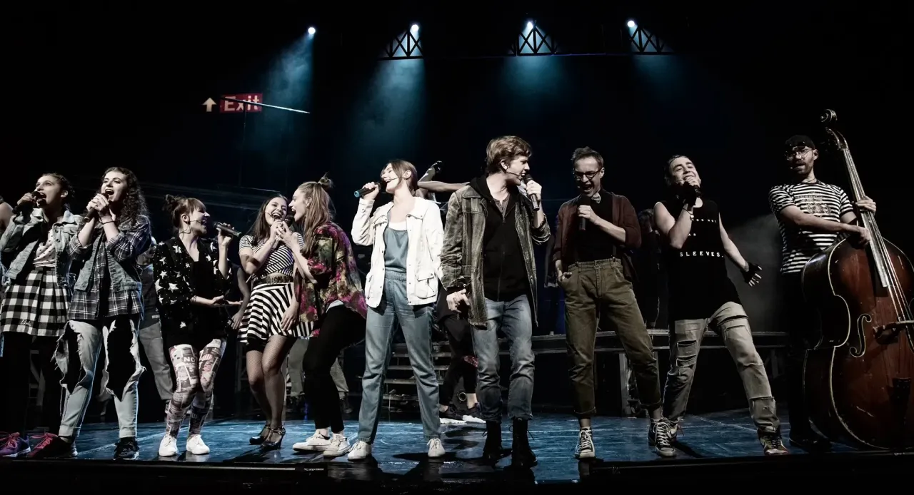 Zespół śpiewa na scenie. Zastanawiasz się, ile trwa musical Metro? To pytanie, na które odpowiedź znajdziesz, oglądając ten spektakl.