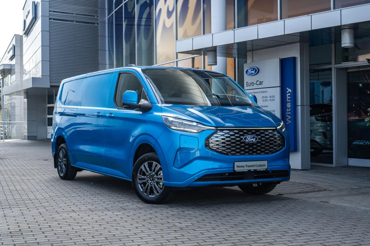 Niebieski Ford Transit Custom przed salonem. Sprawdź jego pojemność baku i wybierz się w długą podr&oacute;ż.