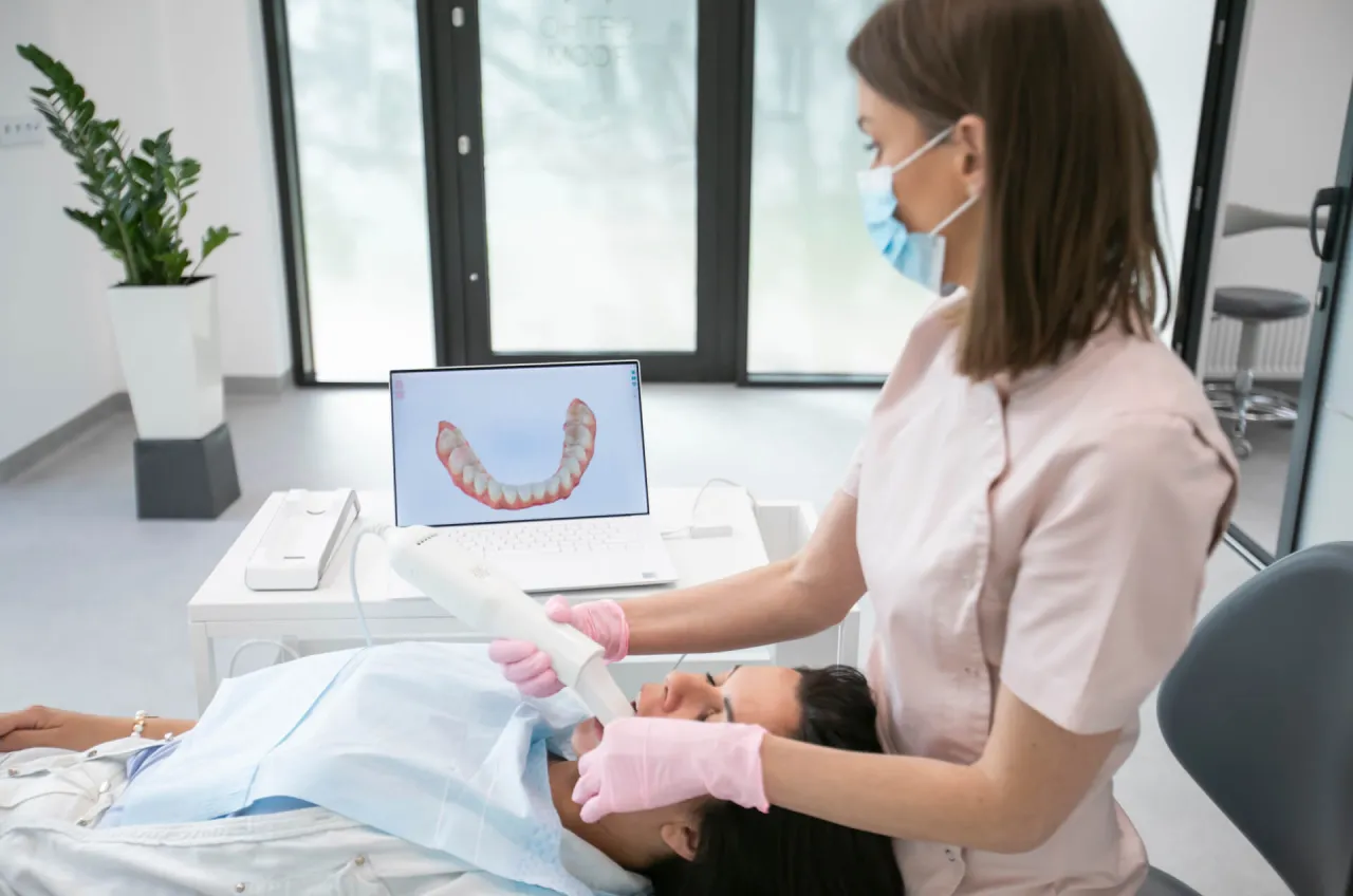 Ortodontka skanuje zęby pacjentki, by zaplanować leczenie. To pierwszy krok, by dowiedzieć się, jak zostać ortodontą.