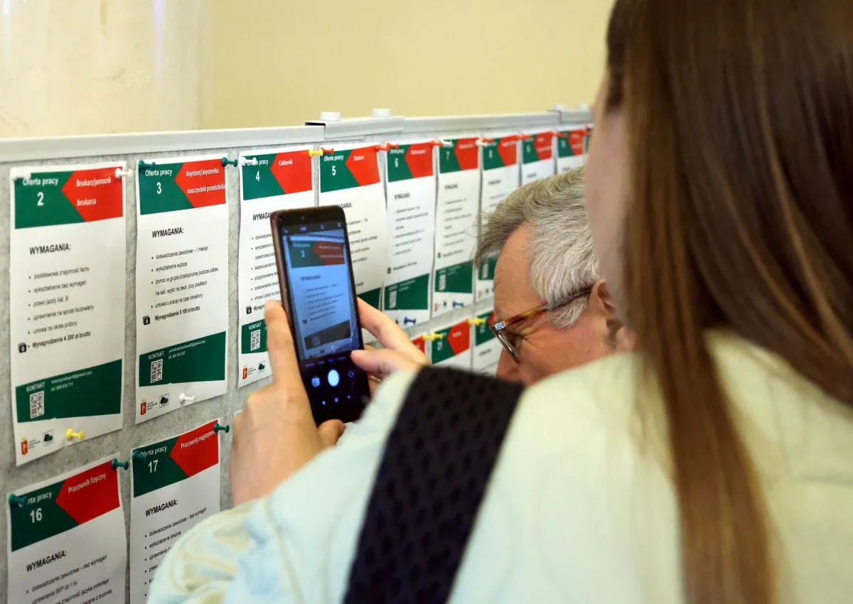 Osoba robi zdjęcie telefonu z ofertą pracy. Czy stażysta może zrezygnować z zatrudnienia po stażu? Sprawdza ogłoszenia.