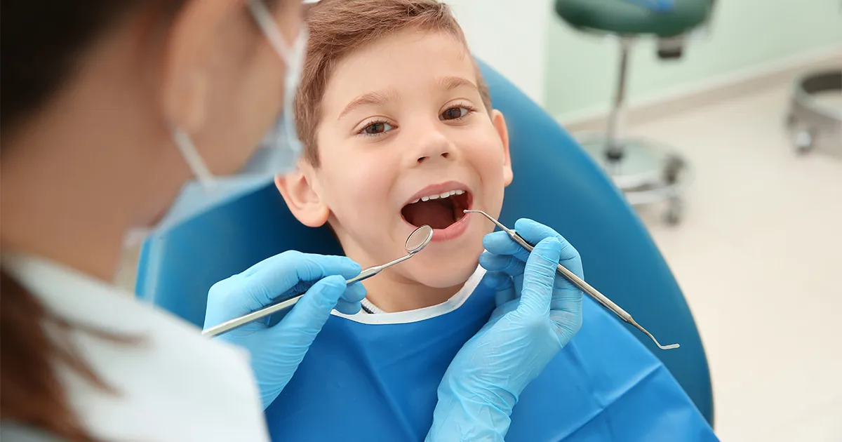 dziecko u dentysty pierwsza wizyta uśmiechnięte