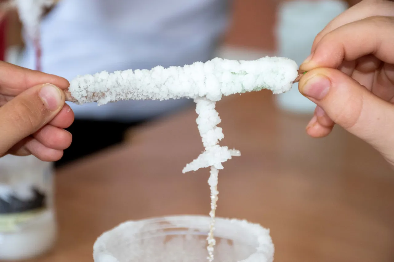 dziecko wykonujące eksperyment z solą i sznurkiem