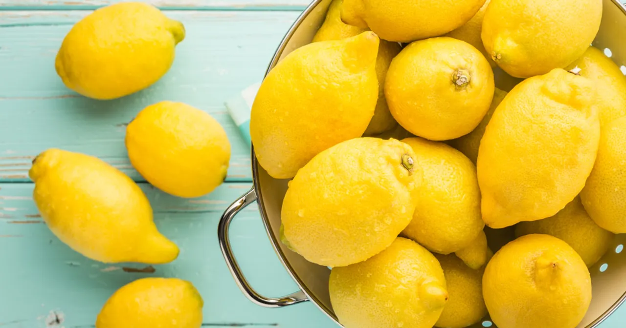 Kupa świeżych, soczystych cytryn w durszlaku i obok. Zastanawiasz się, ile jeść mrożonej cytryny?