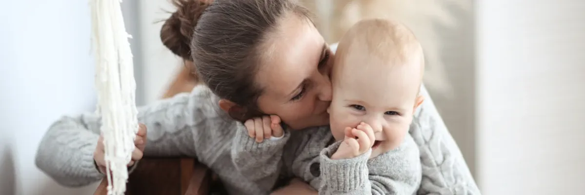 marudne 8 miesięczne dziecko w ramionach rodzica