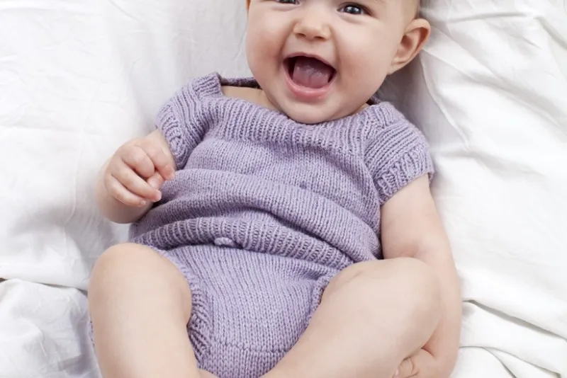 niemowlę w wieku 4 miesięcy, uśmiechnięte i bawiące się