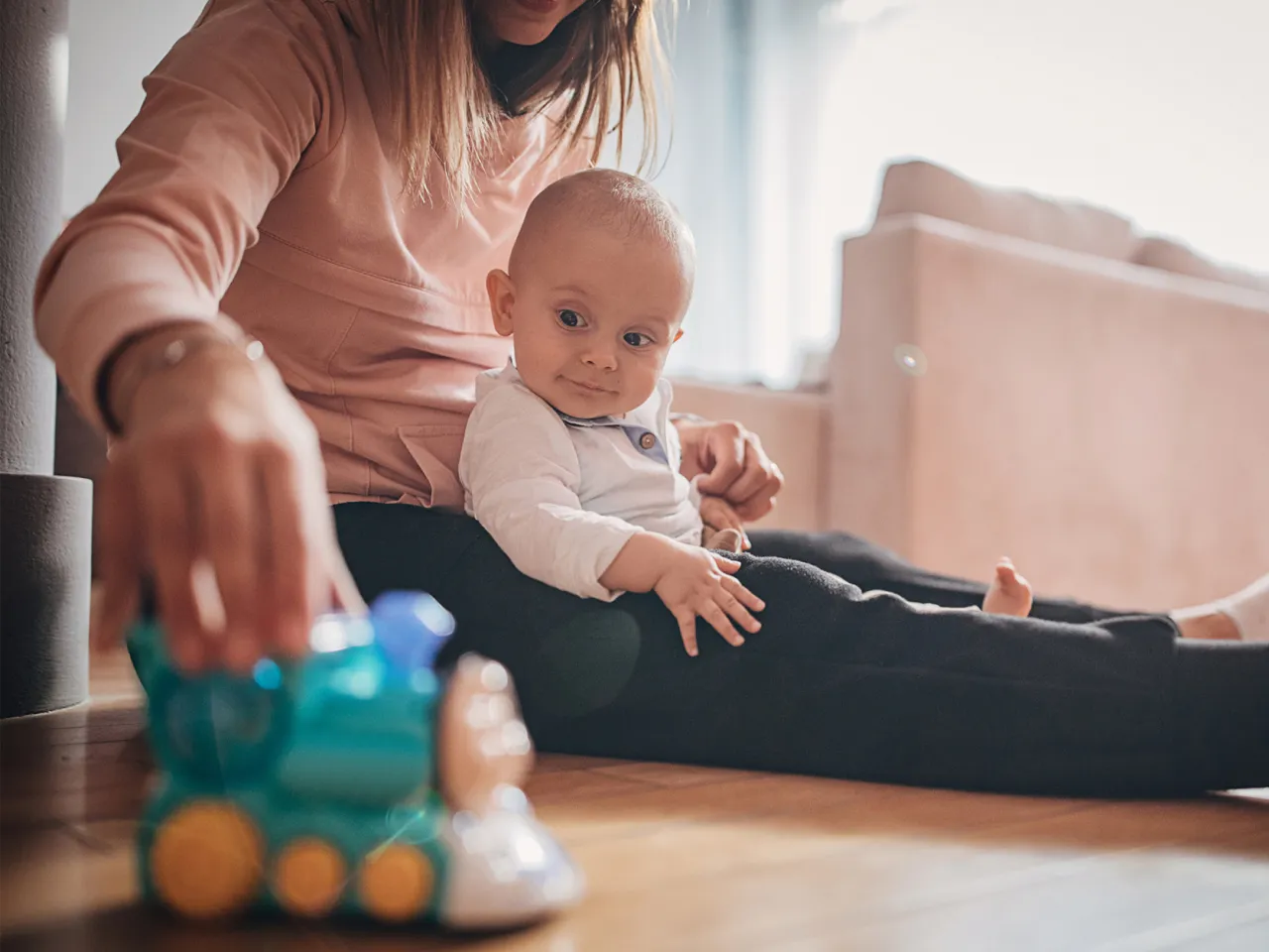 Rodzic bawiący się z 11-miesięcznym dzieckiem na podłodze