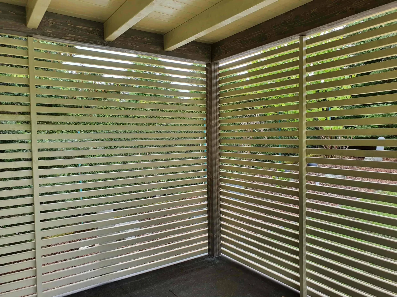 Nowoczesne, ażurowe ściany altany ogrodowej, wykonane z jasnych lameli, tworzą stylową osłonę. To świetny sposób, jak zabudować ściany altany ogrodowej, zapewniając prywatność i estetykę.