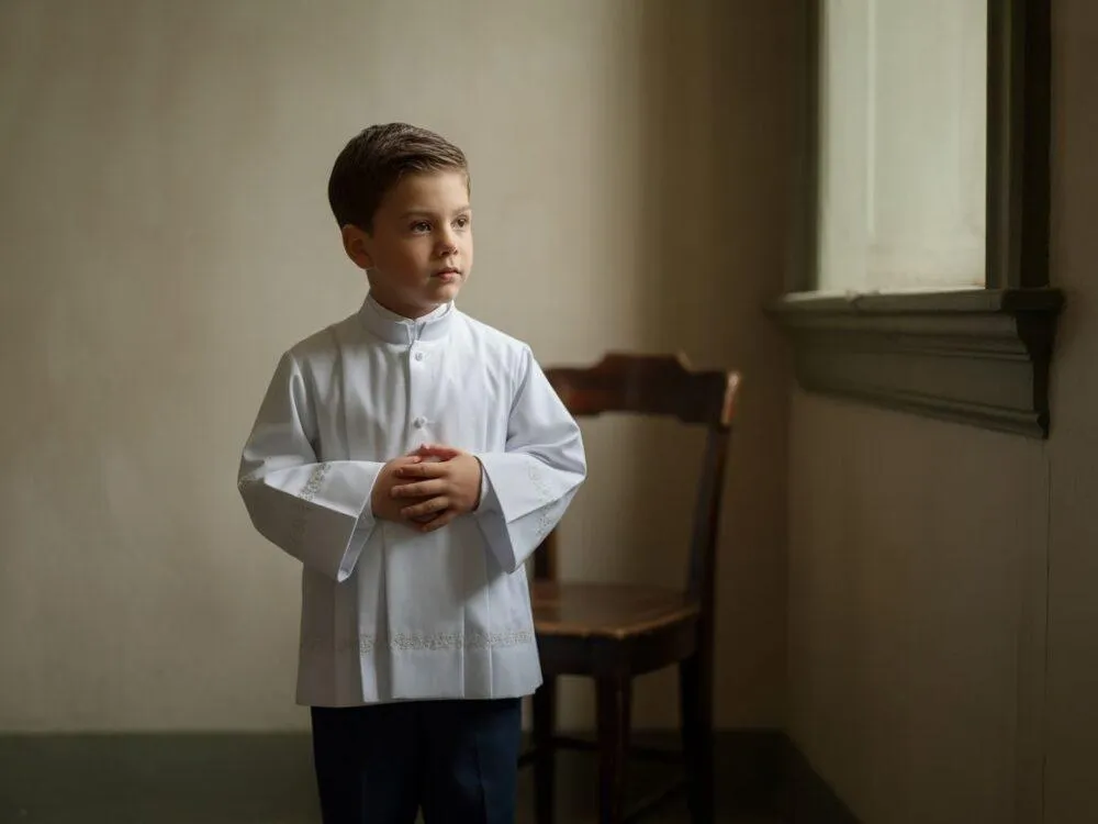 chłopiec w białej koszuli i eleganckich spodniach pod albę komunijną