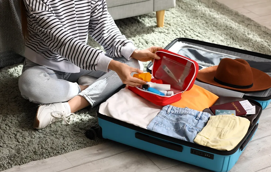 Osoba pakująca leki do torby termicznej przed podróżą