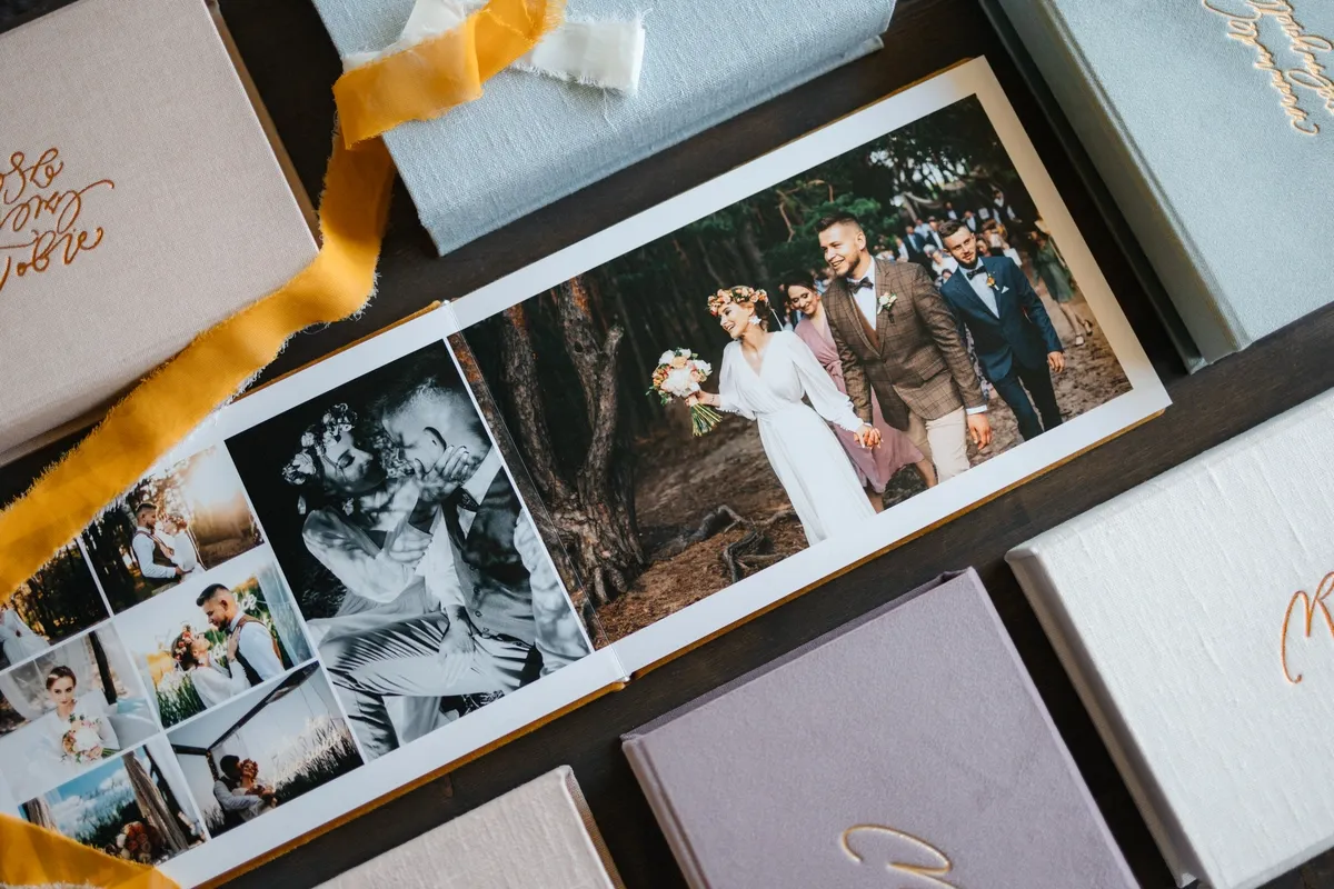 Otwarty album ślubny z kolorowymi i czarno-białymi zdjęciami pary młodej. Warto wiedzieć, jakie pytania zadać fotografowi ślubnemu, by mieć takie pamiątki.