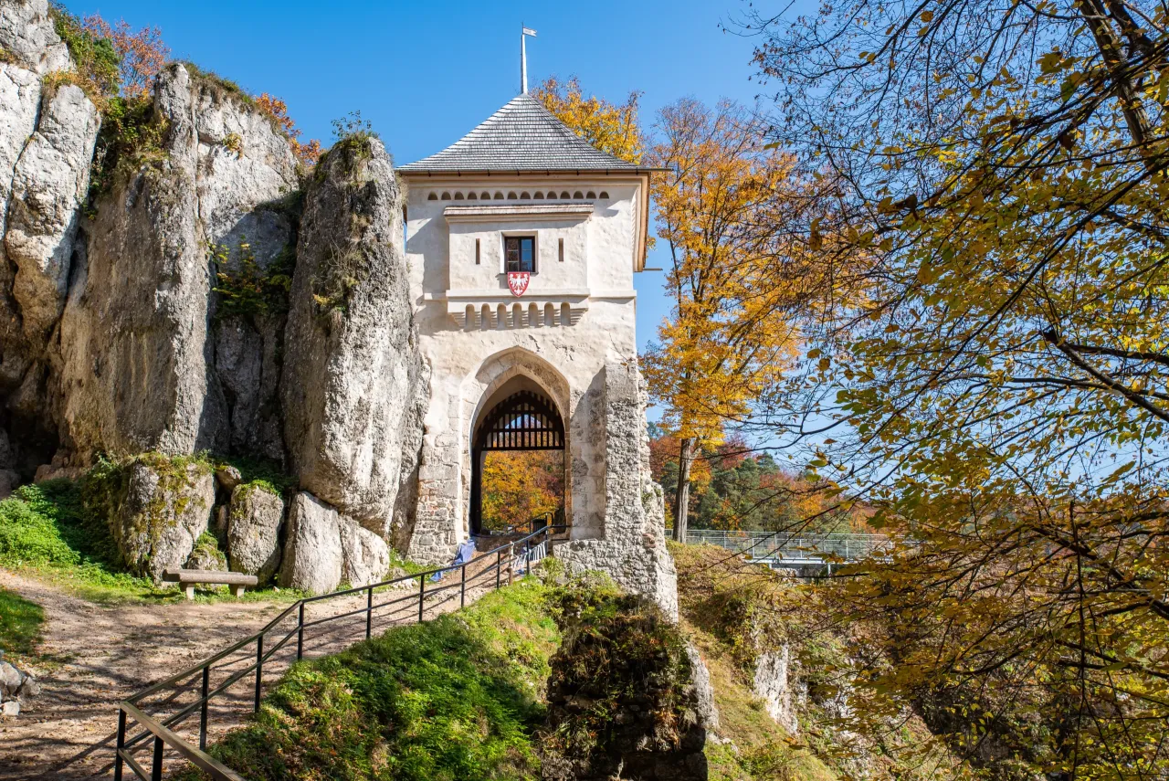 Brama w skale, idealna na trasę rowerową Ojców. Jesienne liście otaczają zamek.