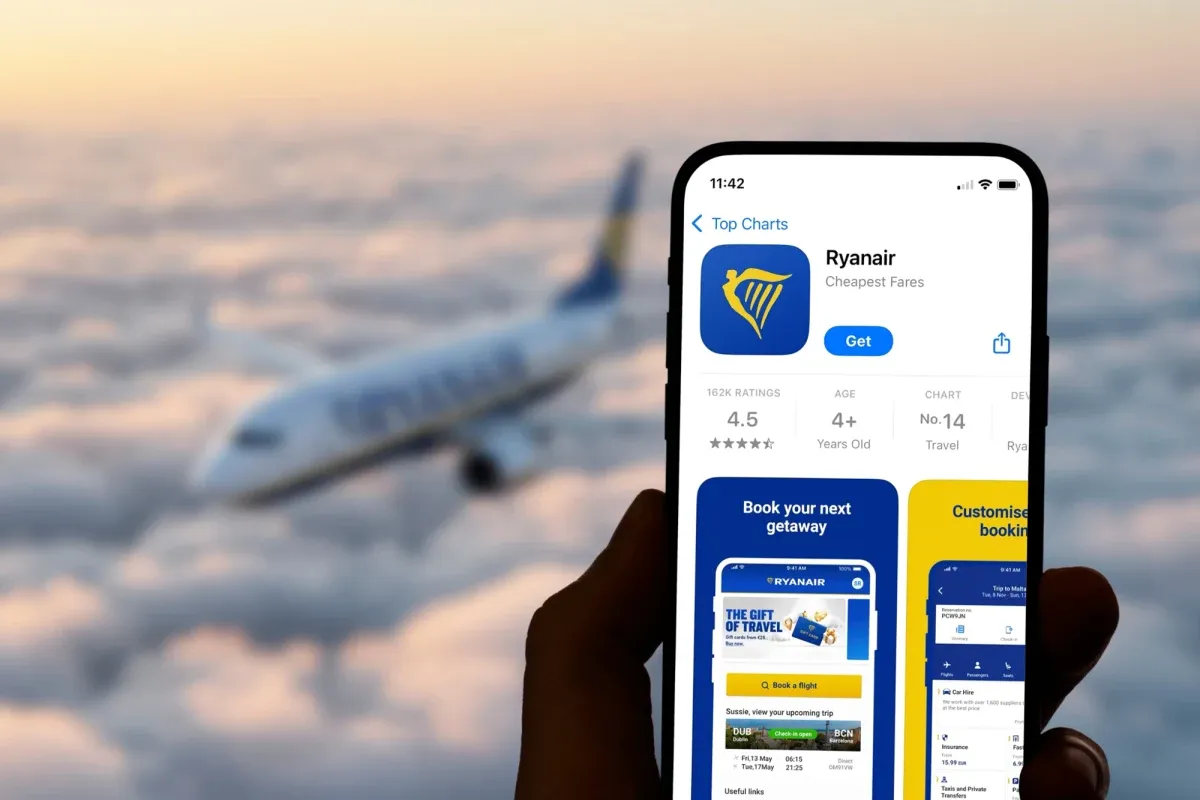 Aplikacja Ryanair na telefonie, z samolotem w tle. Dowiedz się, jak wydrukować bilet Ryanair.