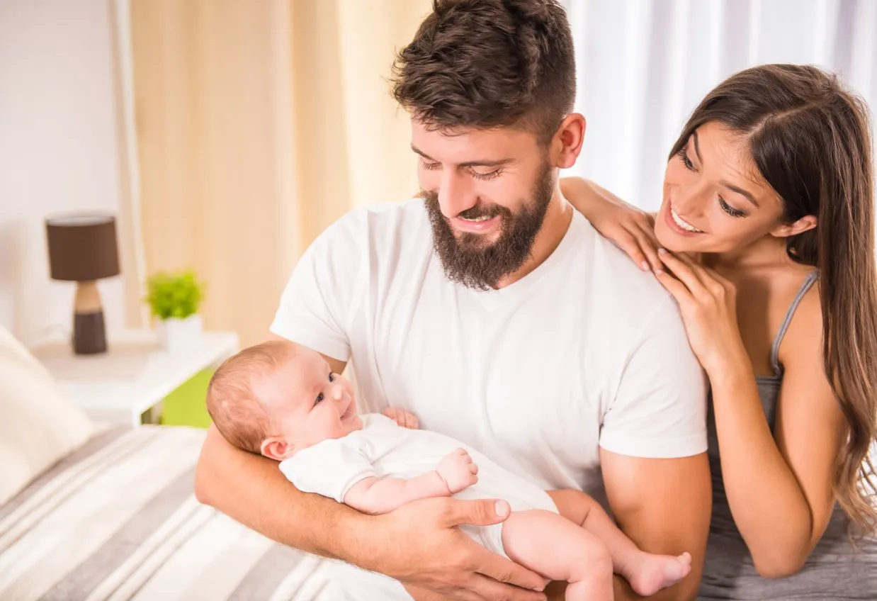 Rodzic ważący niemowlę z uśmiechem