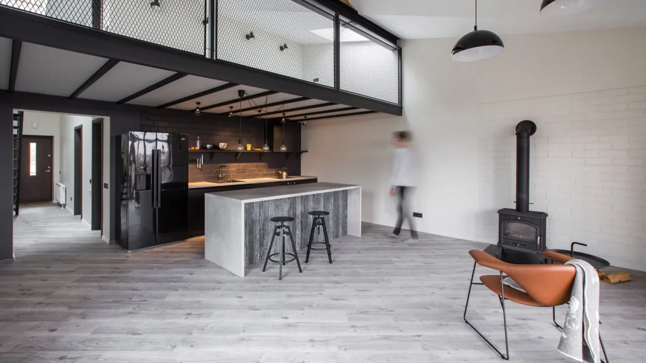 Nowoczesne mieszkanie z antresolą, kuchnią i piecem. Inspiracja, jak zrobić antresolę w mieszkaniu.