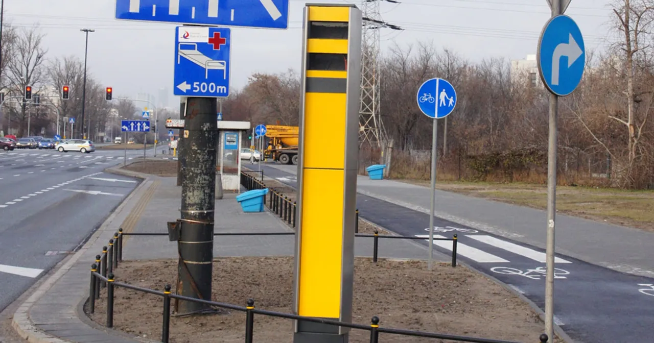 Nowe fotoradary stoją przy drodze, obok ścieżki rowerowej i znaku informującego o szpitalu w pobliżu.