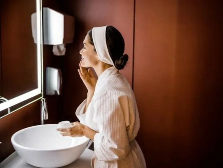 Frau entfernt Make-up vor dem Spiegel, gesunde Haut, abendliche Routine