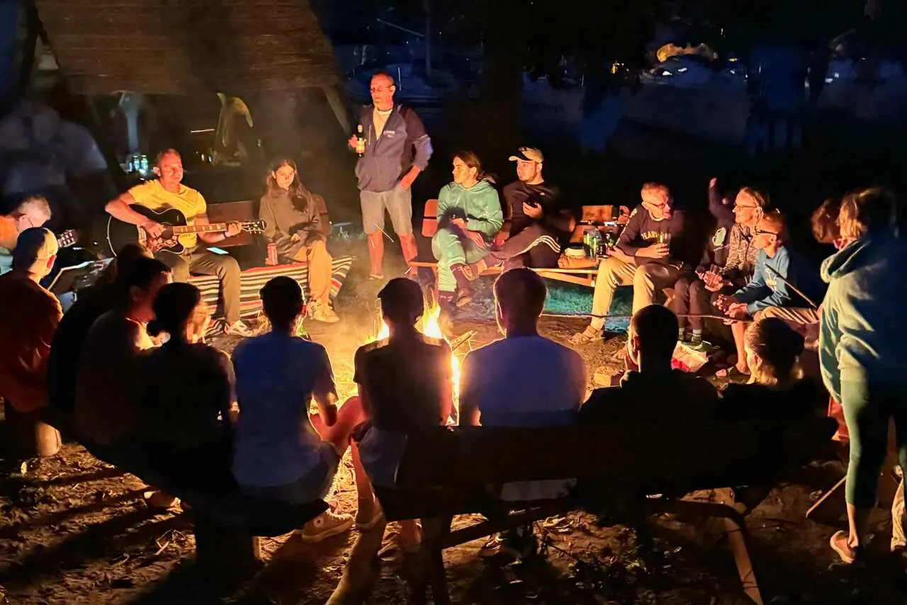 Żeglarze śpiewający przy ognisku z gitarą