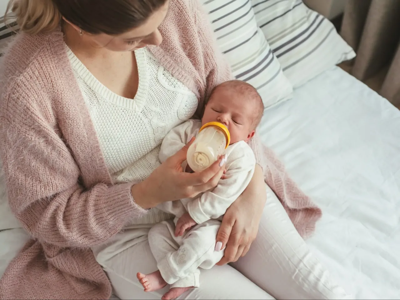 dziecko karmione butelką i piersią