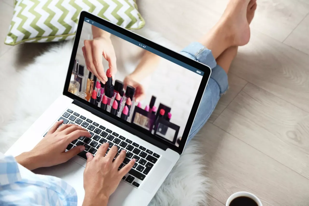 kobieta kupująca kosmetyki online, laptop z otwartymi stronami drogerii