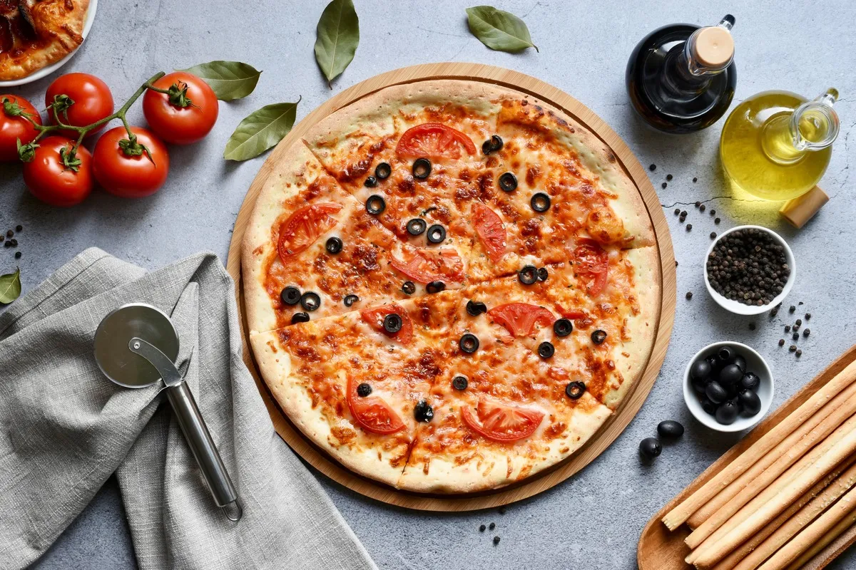 Pyszna pizza bezglutenowa z pomidorami i oliwkami. Idealny przepis na domową ucztę.