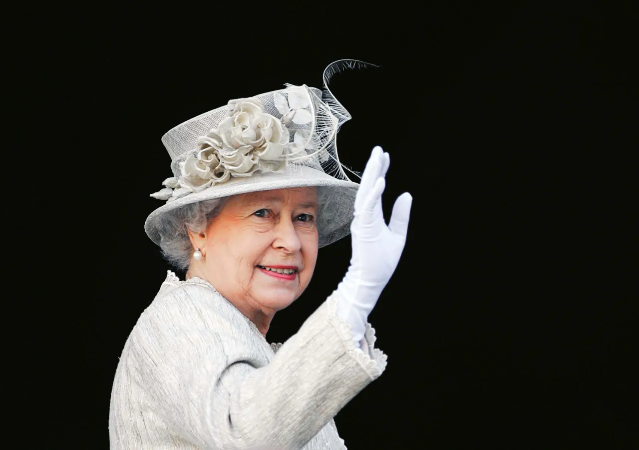 Królowa Elżbieta II, która panowała przez 70 lat, macha do zgromadzonych.