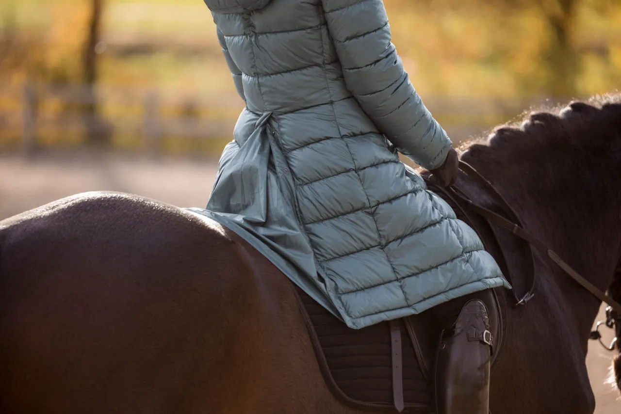 jeździec w zwykłym płaszczu zimowym w siodle