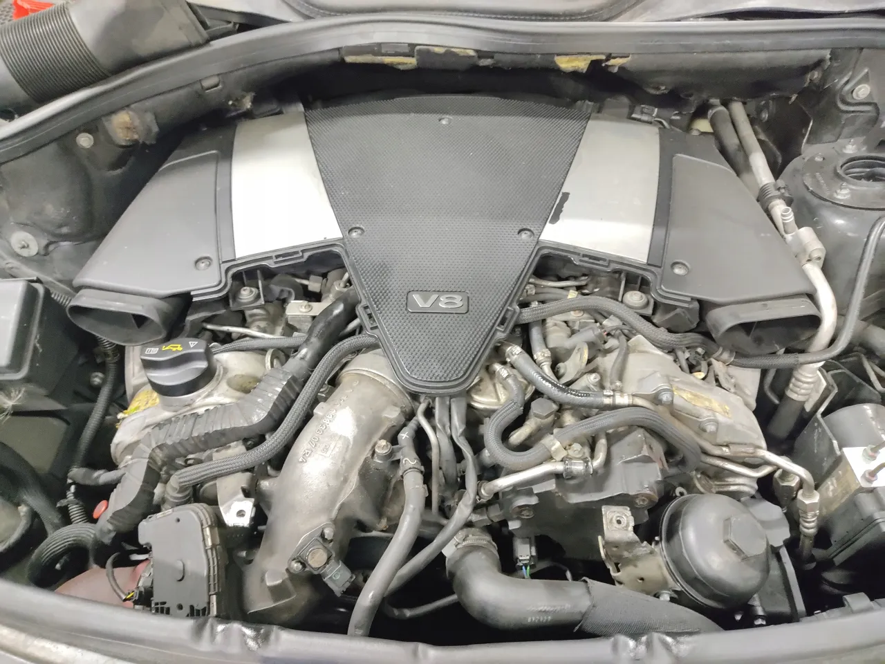 Silnik V8 w Mercedesie Benz GL Class. Widoczne przewody, turbosprężarka i elementy układu dolotowego.