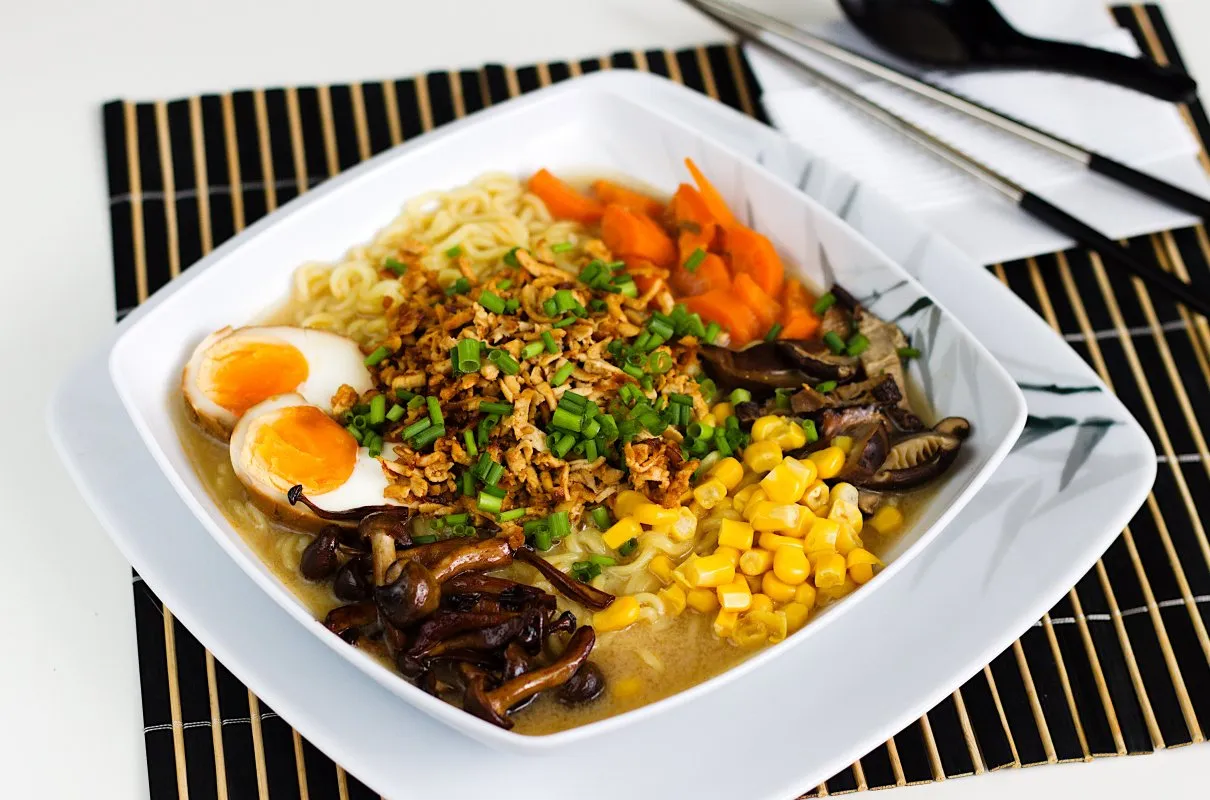 Pyszny tantanmen ramen z jajkiem na pół, kukurydzą, marchewką i grzybami shiitake.
