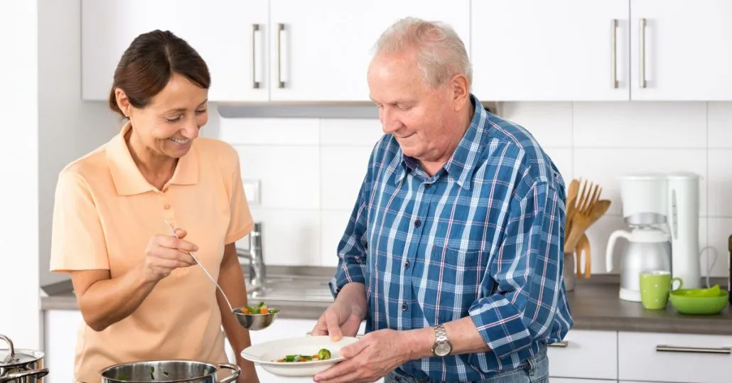 opiekunka pomaga seniorowi w domu