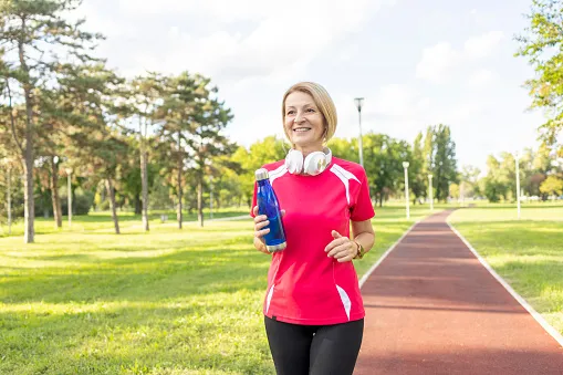 kobieta biegnąca wolno uśmiechnięta park